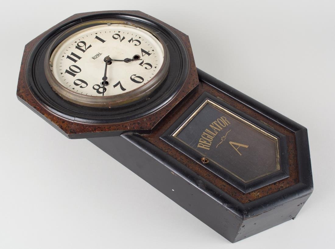 Royal Drop Case Regulator: Painted metal face with Arabic numeral chapters. Height 22 inches. Notice to bidders: Condition reports and additional photographs are provided by request as a courtesy to our clients, as such any con