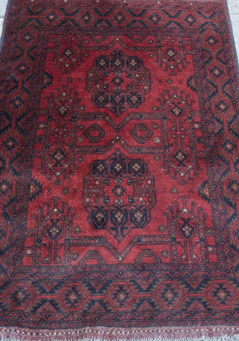Rug: Two medallions on a red field with allover geometric decoration, within a red and black border with similar geometric decoration. 3 feet 4 inches x 5 feet. Provenance: Warren Means Trust Notice to bid