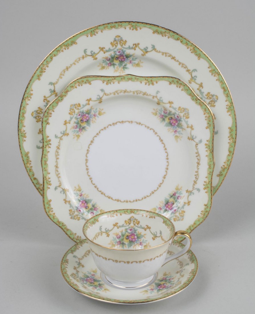 Noritake Porcelain Dinner Service: Approximately one hundred pieces, with gilt rim, green and ivory border, floral sprays, and yellow and green scroll decoration, comprising eleven dinner plates, twelve salad plates, twelve bread plate