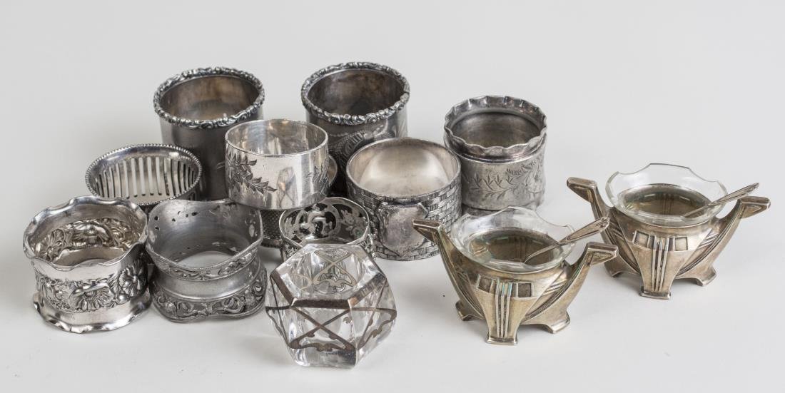 Group of Silver and Silver Plated Table Articles: Comprising a pair of German 800 silver salt cellars with glass liners, a crystal salt cellar and ten silver plated napkin rings. Notice to bidders: Condition reports and additional photographs are pro