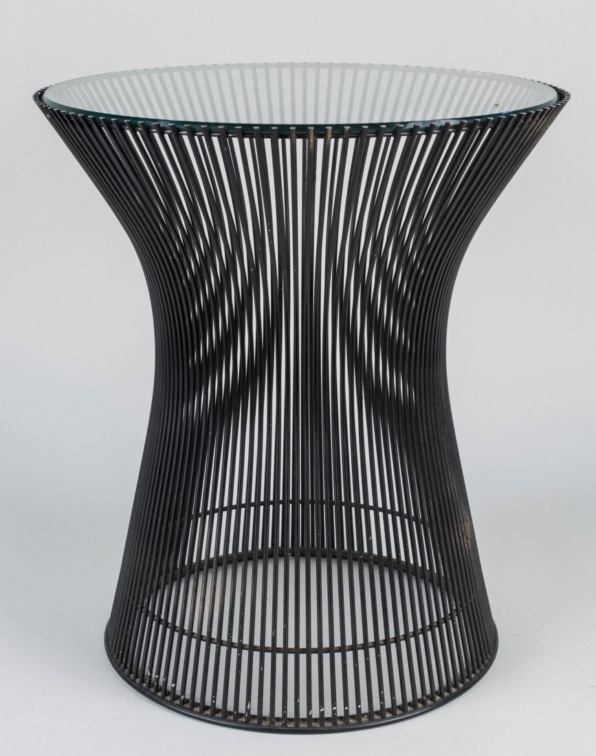 Warren Platner Side Table: Circular glass top on a black metal base. Height 18 inches, diameter 16 inches. Notice to bidders: Condition reports and additional photographs are provided by request as a courtesy to our clients, as