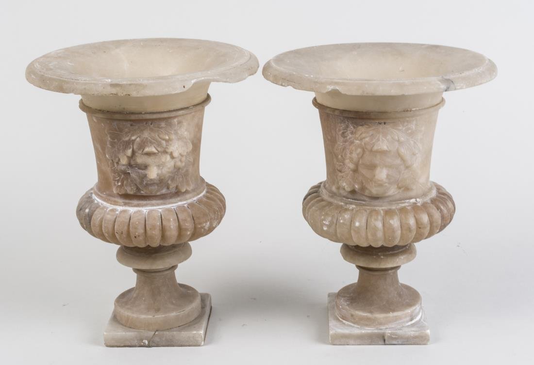 Pair of Alabaster Urns: Campagna form, on square bases. Height 10 inches. Notice to bidders: Condition reports and additional photographs are provided by request as a courtesy to our clients, as such any condition report is 