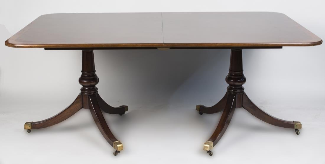 Regency Style Double Pedestal Dining Table: Rectangular top with rounded corners and crossbanded edge, on two pedestals, with two additional leaves. Height 29 inches, width 70 inches, depth 45 inches. Leaf width 20 inches. Notice to bidders: Co