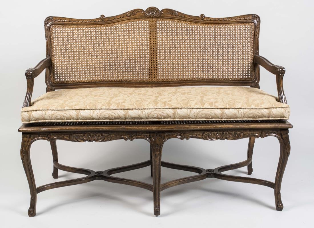 Louis XV Style Caned Back Settee: Cartouche shaped base, open arms and cabriole legs. Height 38 inches, width 50 inches, depth 21 inches. Notice to bidders: Condition reports and additional photographs are provided by request as a cou