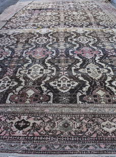 Northwest Persian (Iranian) Carpet: Allover repeating floral and geometric pattern on a brown field within a tan and rose colored border with floral decoration. 26 feet x 16 feet. Notice to bidders: Condition reports and additional phot