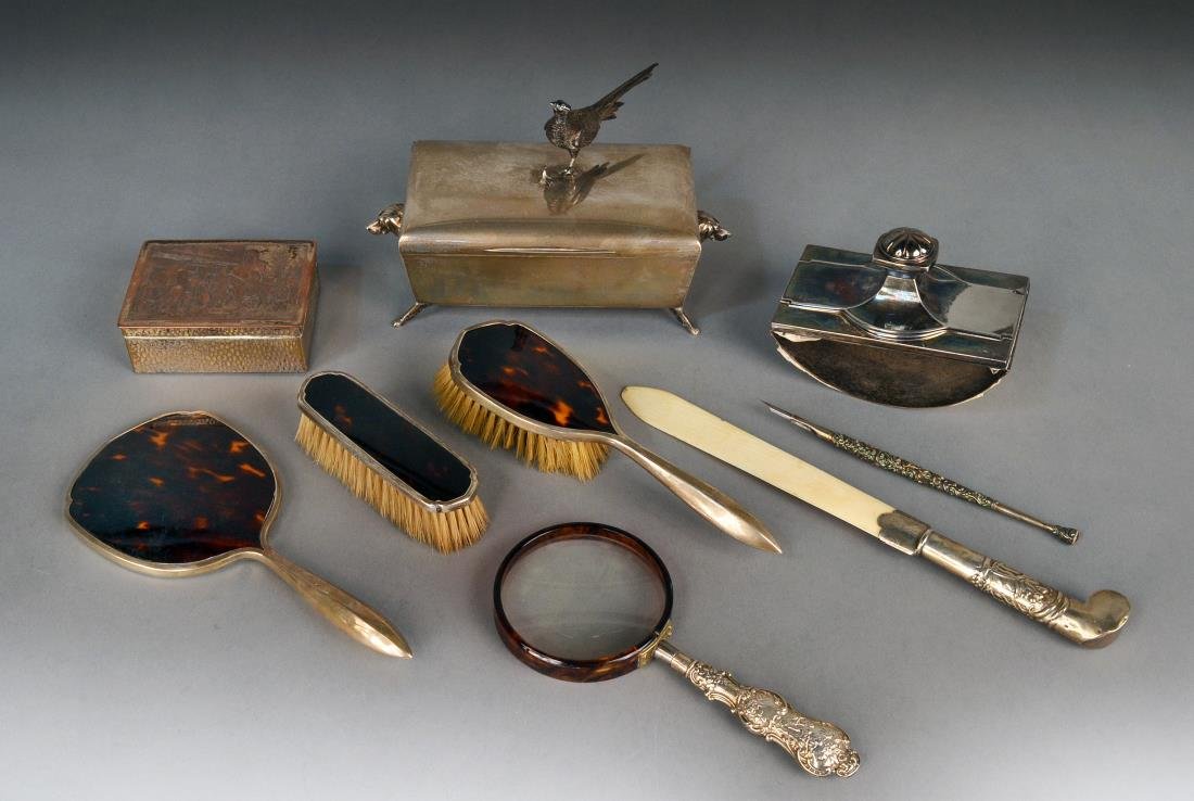 Miscellaneous Group of Desk & Dresser Articles: Comprising two silver plated humidors, sterling silver dip pen, silver mounted ivory page turner, sterling handled magnifier, a blotter and a three piece dresser set including hand mirror, hair brush