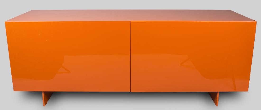 Piero Lissoni Orange Lacquered Cabinet: Rectangular top over two doors opening to glass shelves. Height 27 inches, width 71 inches, depth 24 inches. Notice to bidders: Condition reports and additional photographs are provided by request as 