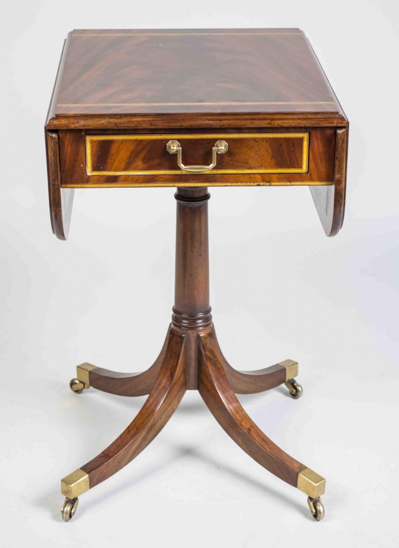 Mahogany Drop Leaf Table: Rectangular top with cross banded edge and two drop leaves, with rounded corners, above a single drawer, on a columnar support on a quadripartite base with four splayed legs ending in brass casters. C