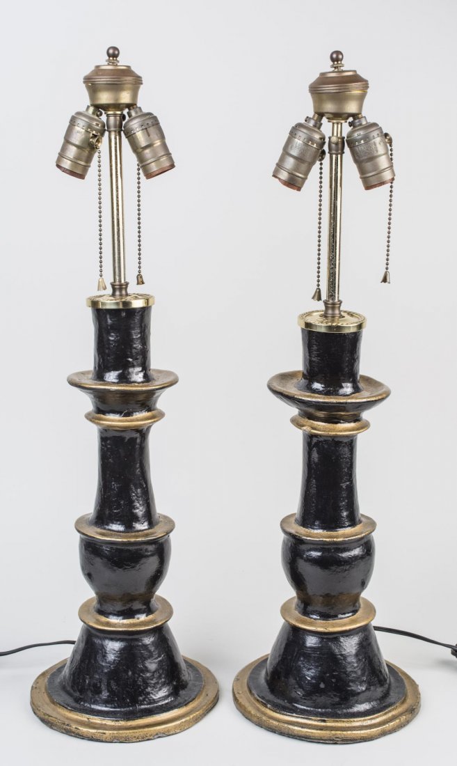 Pair of Black and Gold Painted Table Lamps: Each a two light lamp. Overall height 25 1/2 inches. Notice to bidders: Condition reports and additional photographs are provided by request as a courtesy to our clients, as such any condition report 