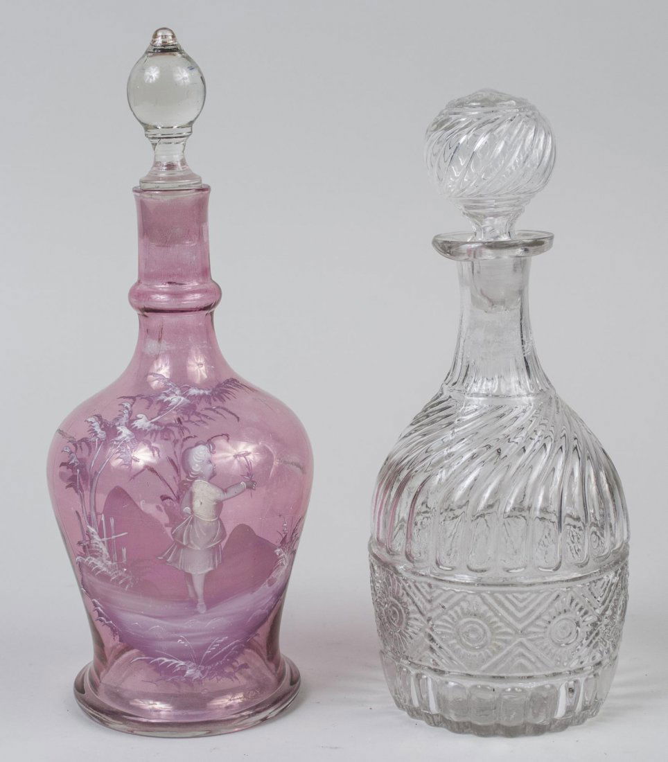 Two Hand Blown Glass Decanters: One, Victorian style colorless glass decanter with molded gadrooned decoration, height 11 inches; the other in the style of Mary Gregory with white enamel decoration on pink glass, height 12 inches. N