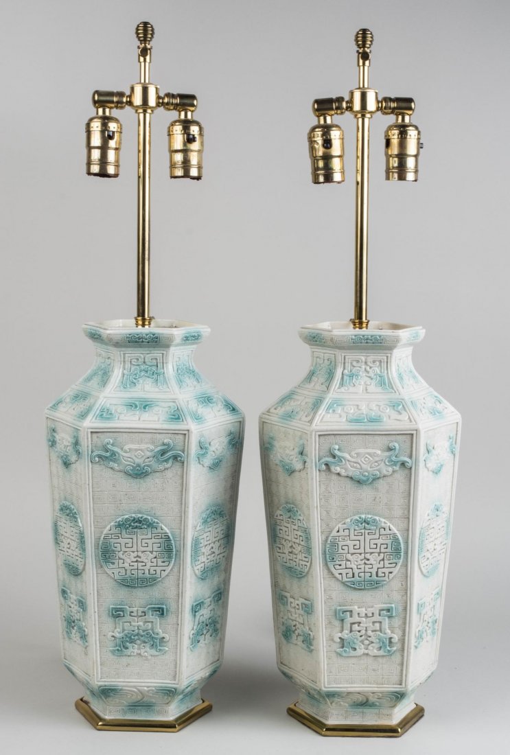Pair of Porcelain Lamps: Chinese porcelain vases, with raised decoration of calligraphy, mounted as two light lamps, white silk shades. Base, height 16 inches. Notice to bidders: Condition reports and additional photographs a