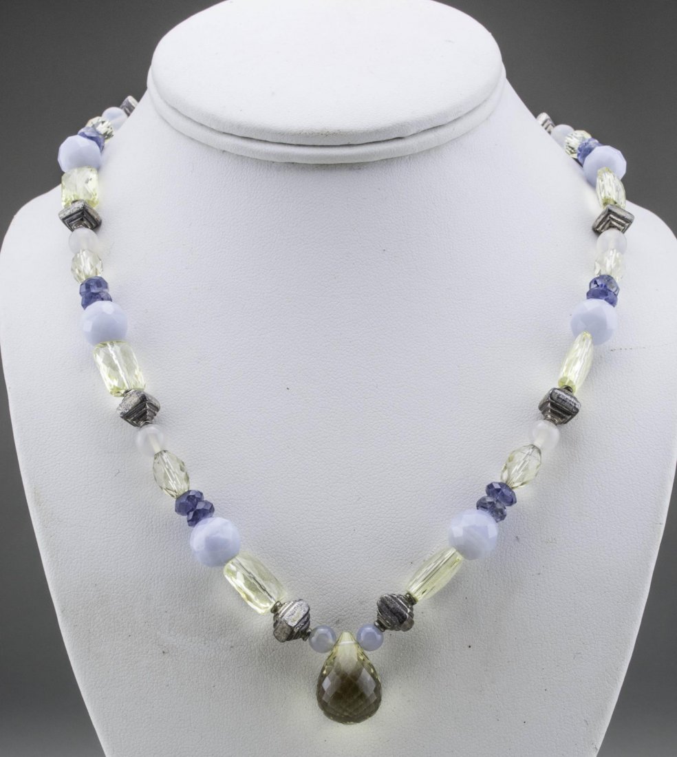 Gemstone Bead Necklace: Various shaped, faceted chalcedony, iolite and silver beads with teardrop bead at the center and sterling silver clasp. Length 18 inches. Notice to bidders: Condition reports and additional photograph
