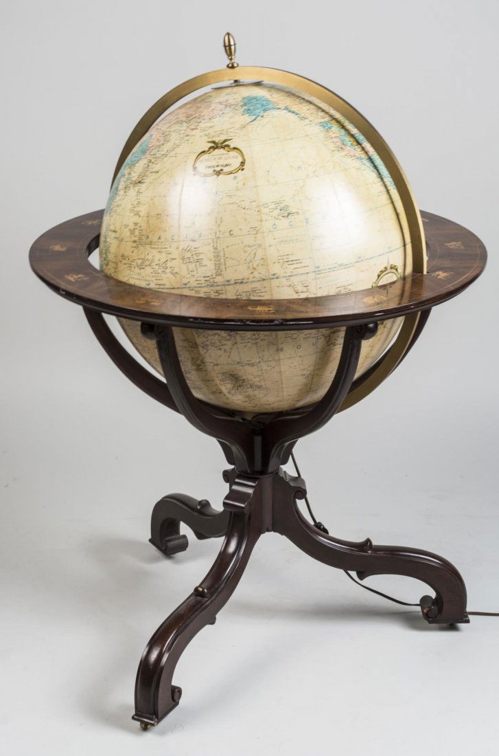 Illuminated World Globe on Stand: Circa 1980, pivoting and rotating world globe on a mahogany stand decoratin with signs of the zodiac. Electrified. Height 41 inches, diameter 30 inches. Notice to bidders: Condition reports and additi