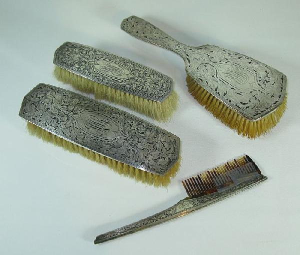 Sterling silver dressing table set: four pieces with engraved design, including: bristle hand brush 9" (needs to be reset), bristle brush 7", bristle brush 6", tortoise shell comb (one broken tooth).