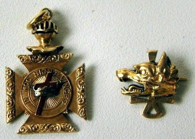 Two fraternal pins: one with a wolf's head is inscribed "N.W. Green '94", stamped Tiffany & Co. 18k gold; the large pin gold unmarked