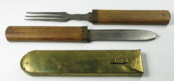 Two early pieces: a wood & brass-cased steel knife and fork, 8in.; and a brass case, 6in., with mark DEKEMEL.