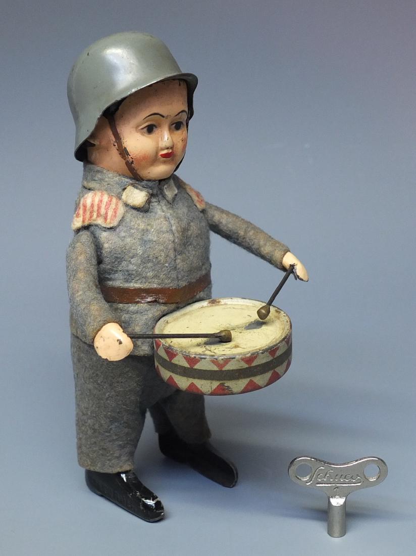 SCHUCO GERMAN 991/1 THIRD REICH SOLDIER DRUMMER WINDUP: Made in Germany by Schuco. 1930's fabric covered tin wind up 991/1 Third Reich Soldier Playing Drum, comes with Schuco key. 5" high.