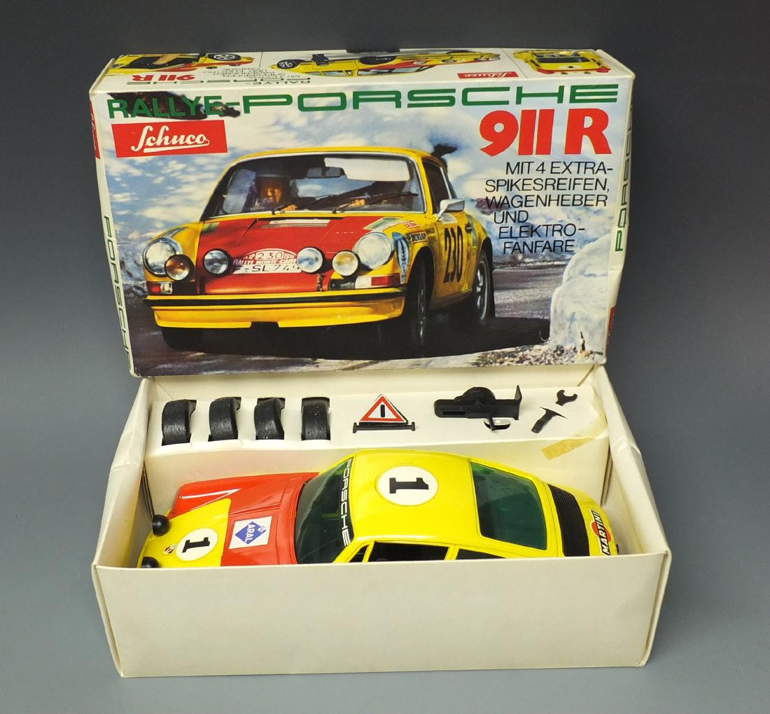 SCHUCO 356218 ELEKTRO RALLYE PORSCHE 911 R & BOX: Made in Germany by Schuco. 1960's battery operated 356 218 Elektro Rallye Porsche Shell Martini 911 R car with all of the original accessories, spare tires and box. 10.5" long.