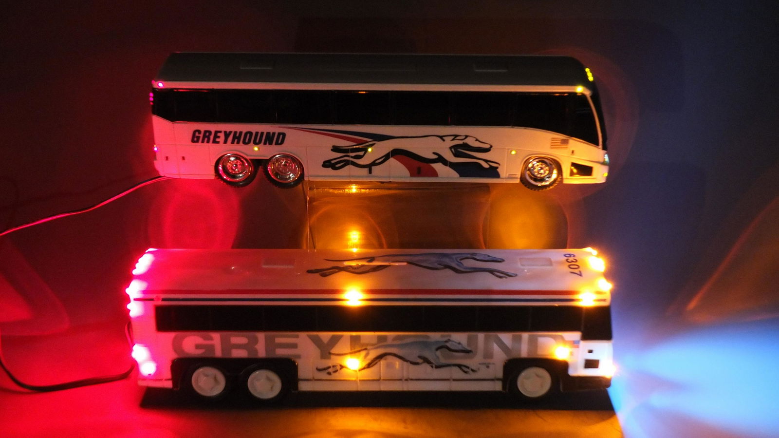 2 CUSTOM LIGHTED GREYHOUND BUS BANKS: Lot of 2 Plastic Vintage Buses Includes: 1 Royal Coach Greyhound Bus Bank Customized with Electric Lights (But is No Longer a Bank) and 1 Lighted Greyhound Bus Coin Bank. Approx. 10" L