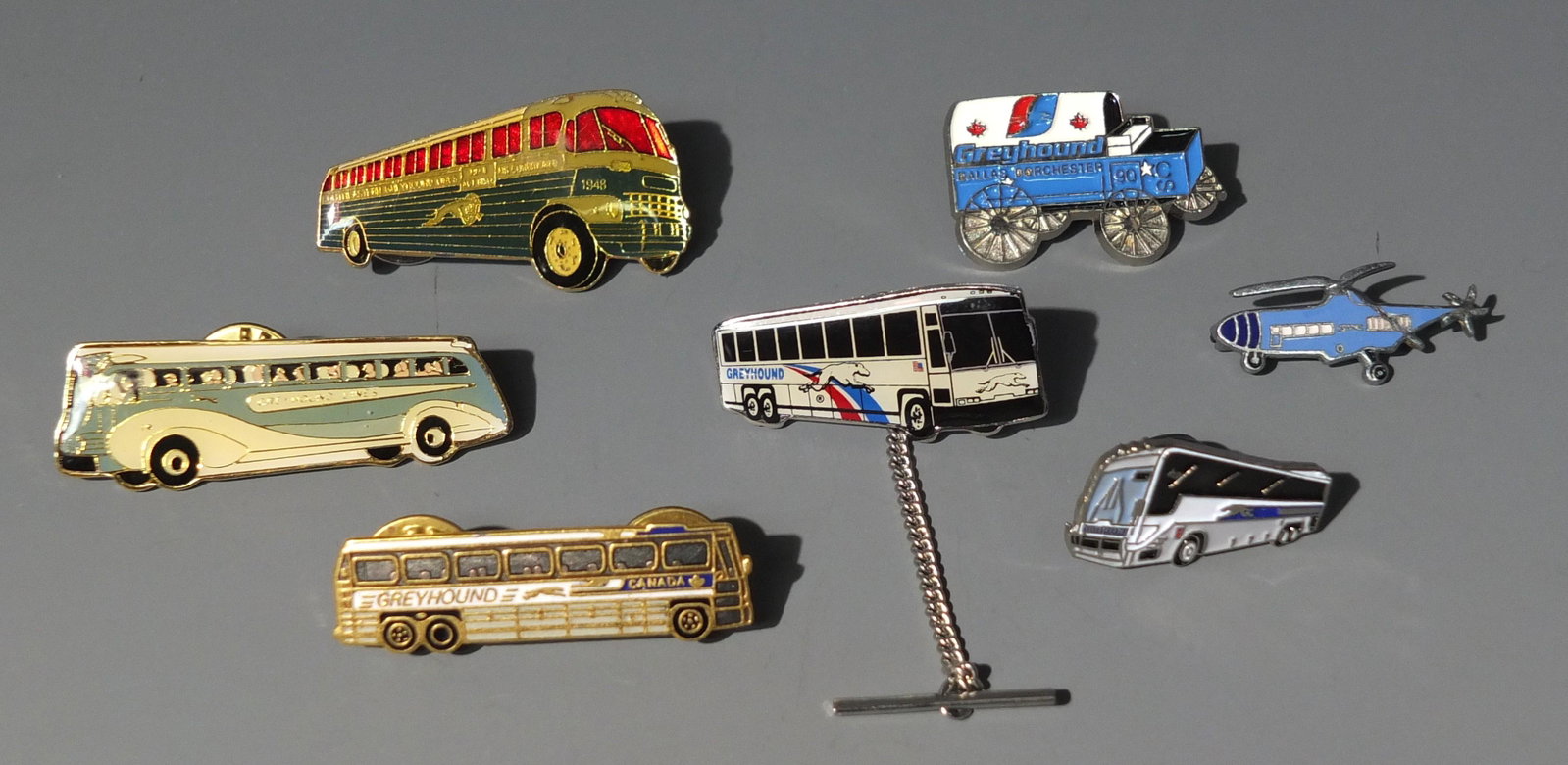 7 ENAMELED GREYHOUND BUS PINS: Lot of 7 Enameled Greyhound Bus & Other Vehicle Lapel Pins.