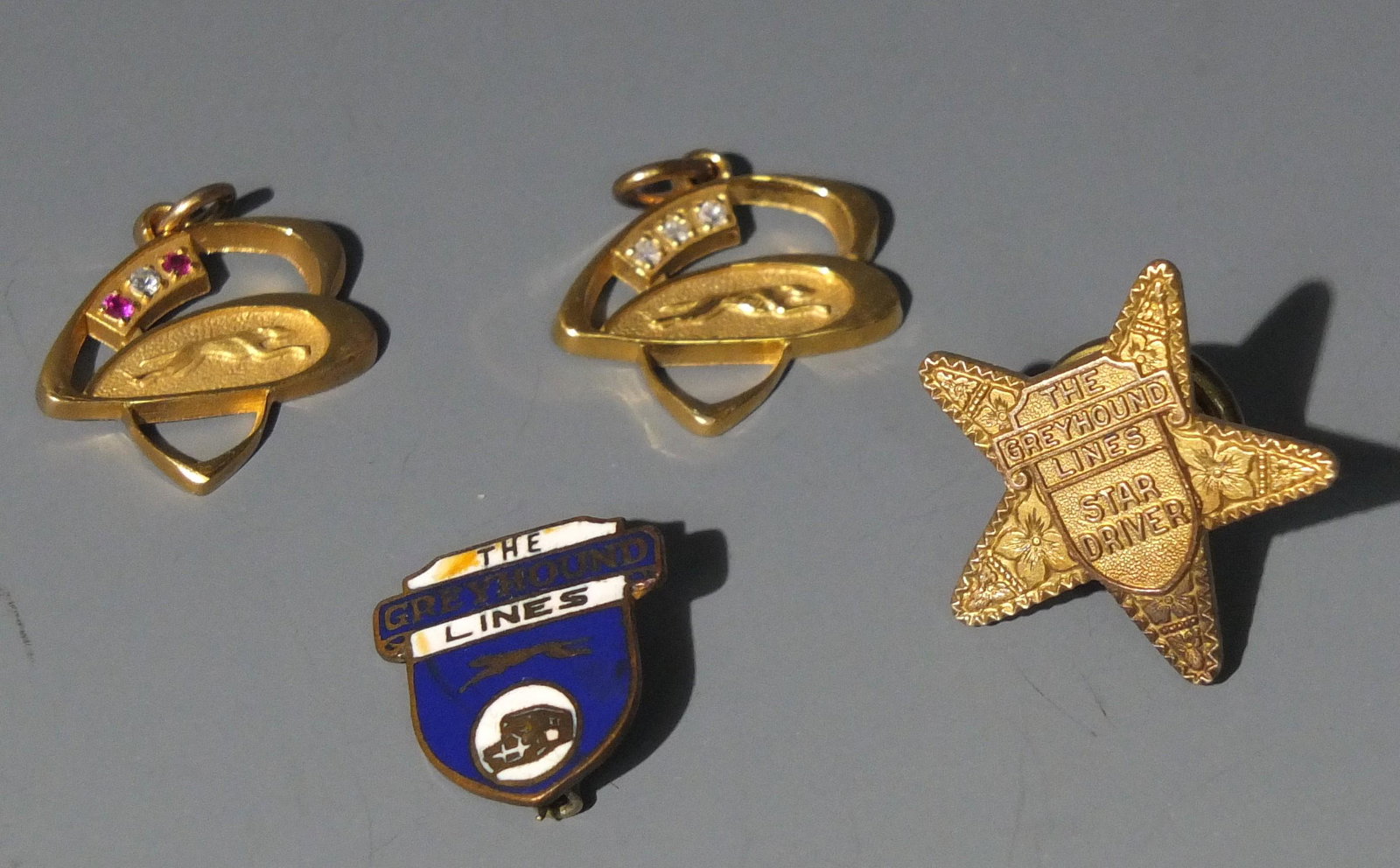 GOLD & JEWEL GREYHOUND PENDANT & PINS: Includes: Two 10K Gold, Diamond & Gem Necklace Pendants and Enameled Greyhound Pin & Greyhound Bus Star Driver Service Pin.
