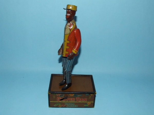 MARX DAPPER DAN COON JIGGER PORTER TIN WIND UP: 1910. USA. Working. Complete. All Original. This is the harder to find more desirable version of the two Dapper Dan toys made. In this version, Dapper Dan is a porter and he dances on top of a large t