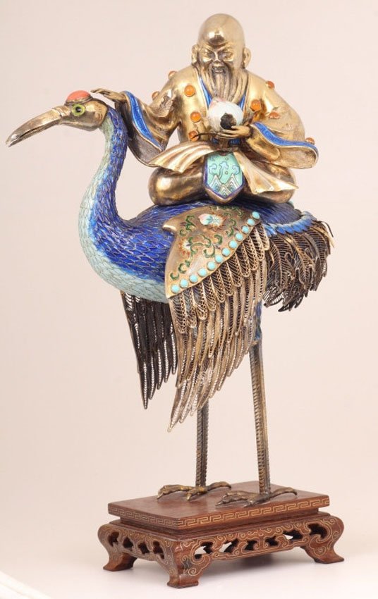 CHINESE GILT METAL AND CLOISONNE FIGURE ON CRANE: Shoulao seated on crane, 20th century Overall height- 12" Overall weight with stand- 24.4 troy oz.