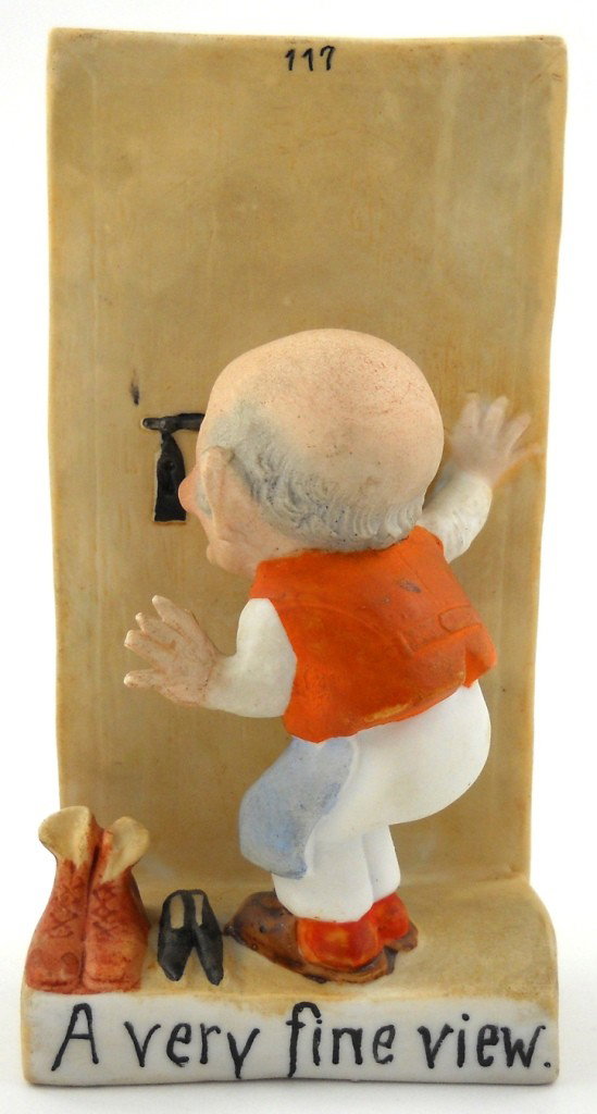 Schafer & Vater Figure - "A Very Fine View": This porcelain could be a bud vase, as it has a small curved container on the back. An old man is looking through a key hole, with the title "A very fine view." It looks to be made by Schafer & Vater 