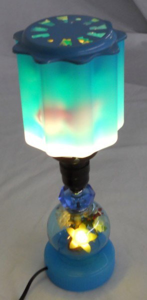 1950s "Merry Lamp" Motion Light: This unusual table motion lamp has a blue and white encased glass shade on top. The ribbed shape of the shade makes the fish on the spinner inside look as if they are swimming as they go by. There is