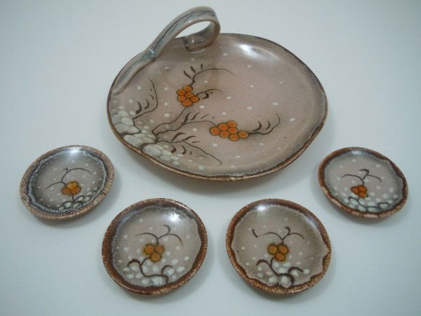 Gouda "Friso-Zenith" small serving piece and four: This lot is a 5 piece set of Gouda pottery. There is a serving dish with a thumb handle and 4 very small plates with a red berry and vine pattern. The larger dish is 7" inches across, and 2 1/2" high