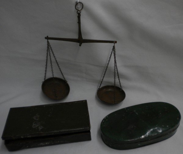 Two Sets of Mining Scales: One is in a green rectangular 6 3/4" x 3 5/8" metal box and contains a 6" beam with 2 3/4" pans; no weights. Some wear on box. The other is in a green oval tin box measuring 7" x 3 5/8", and has a 6 5