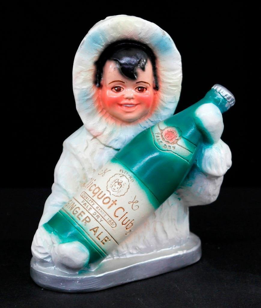 Clicquot Club Figural Chalk Bank: This is a vintage Clicquot Club figural chalk advertising bank of a parka clad Clicquot Club Eskimo child holding a bottle of ginger ale. This piece is approximately 7 inches tall x 5 inches long at t