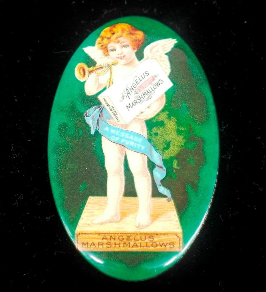 Angelus Marshmallows Celluloid Oval Pocket Mirror: This beautiful celluloid mirror for Angelus Marshmallows is approximately 2-3/4 inches long x1-3/4 inches across. It shows cupid holding a box of marshmallows and a trumpet. The rim reads, "Mirror Fre