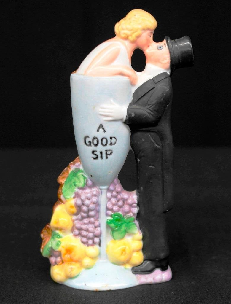 "A Good Sip" Schafer & Vater Colored Nipper Flask: This vintage Schafer & Vater piece is a colored nipper flask and is titled, "A Good Sip," featuring a woman in a glass with a man in formal attire stepping up to kiss her. This piece comes complete wi