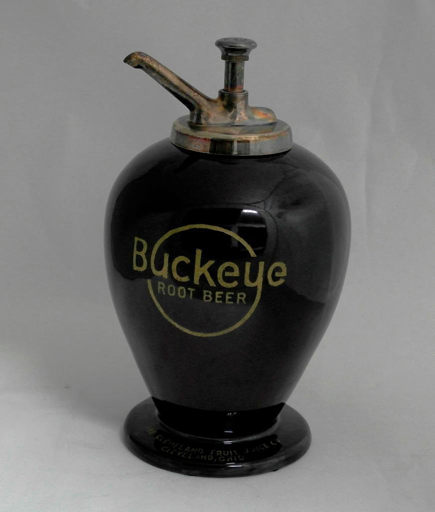 Buckeye Root Beer Syrup Dispenser: Offered is a large ceramic or porcelain Buckeye Root Beer Syrup dispenser. This piece is in the usual urn shape that this company used for their dispensers. However, this dispenser is rather unique as