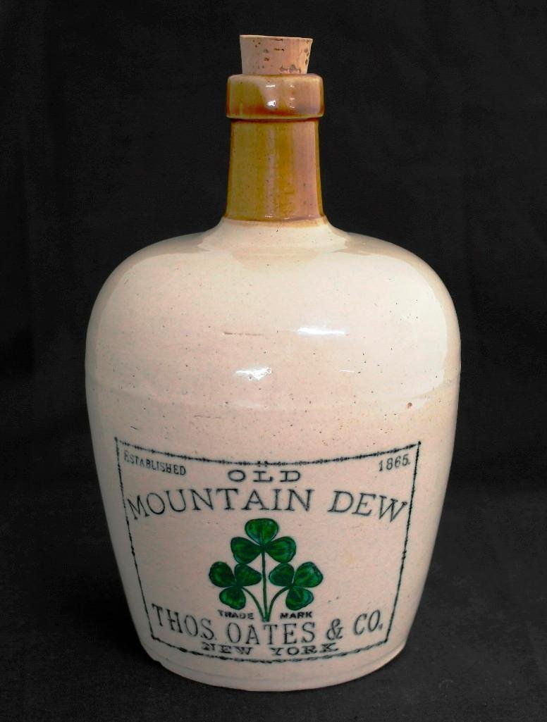 Pre-Prohibition Whiskey Jug for "Old Mountain Dew": This lot is for a pre-prohibition era stoneware advertising jug for "Old Mountain Dew" from "Thos. Oates & Co. of New York." The jug measures approximately 7-1/2 inches x 4-3/4 inches. The green and b