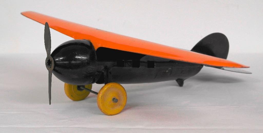 Wyandotte Tin Airplane with Wooden Wheels: This lot is for a vintage single prop airplane. It was made by Wyandotte and is orange and black with yellow wooden wheels. This is a great looking toy and is approximately 18" wide x 12" long x 4-1/2