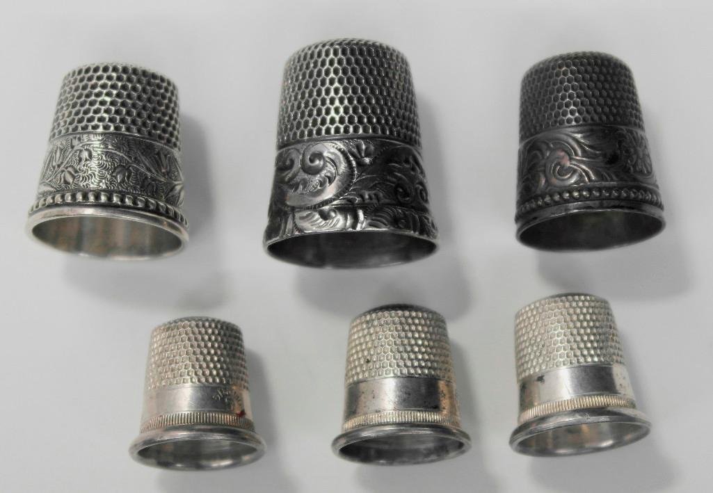 Sterling Silver Thimbles: This lot is for six (6) sterling silver thimbles. Each one is marked Sterling either inside or along the base. The largest thimble is the fanciest one with a hallmark or makers mark on the inside bott