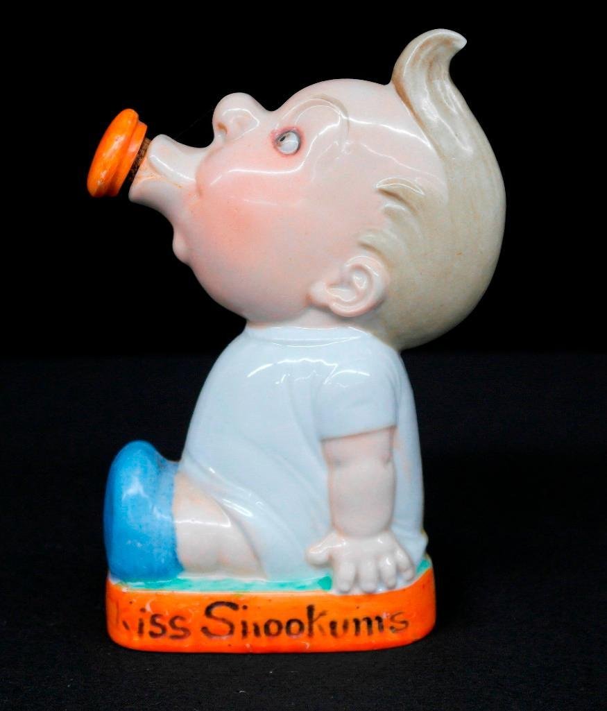 Schafer & Vater "Kiss Snookums" Colored Nipper: This Schafer & Vater colored nipper flask depicts a baby sucking on a pacifier and is one of the flasks from the faces/heads series. The inscription near the bottom states "Kiss Snookums." This piece