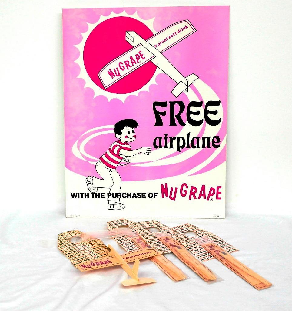 NuGrape Soda Display with Toy Planes: This lot is for a vintage store display from NuGrape Soda. It shows a young boy playing with a toy airplane and announces that you can get a "Free Airplane with the Purchase of NuGrape."