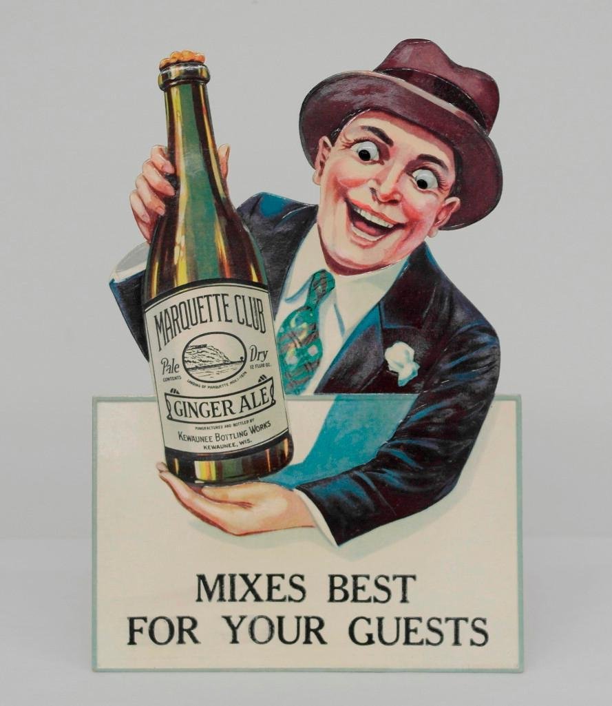 Marquette Club Ginger Ale Die-Cut Sign With Glass Eyes: This unusual sign was made in Germany for Kewaunee Bottling Works of Kewaunee, Wisconsin. What makes this sign different is that it has glass eyes. This sign is made from high gloss stock an