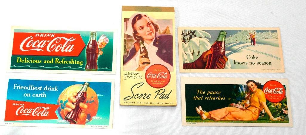 Five (5) Assorted Coke Items: The first item in this lot is a complete, unused bridge score pad from 1943 featuring a U.S. Army nurse. The remaining four items are unused blotters dated 1941, 1947, 1951, and 1956. All five p