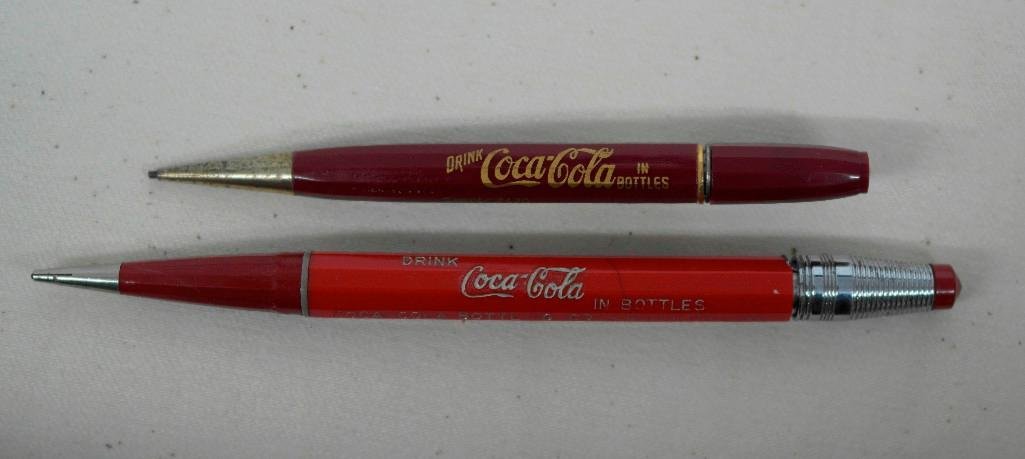 Coca-Cola Mechanical Pencils: Offered are two different vintage mechanical pencils that advertise Coca--Cola. Both pencils are in working order with the larger one measuring 5-3/8" long x 3/8" in diameter with the second