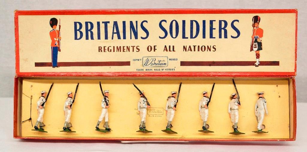 Britains #1253 United States Sailors in Box: This is an 8-piece boxed set of United States Sailors at the slope with their officer. These soldiers wear brown belts, brown gaiters, and solid sky-blue flaps on the shoulders. In 1952 the uniform wa