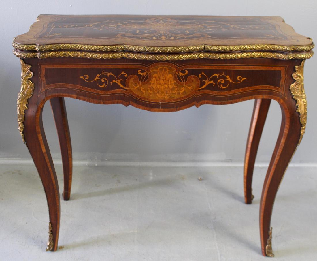 Continental Marquetry Inlaid Flip Top Game Table: Continental marquetry inlaid flip top game table with elaborate bronze gilt ormolu. Table has cabriole legs covered with inlay and metal mounting, top has newer green felt playing surface, faces of Me