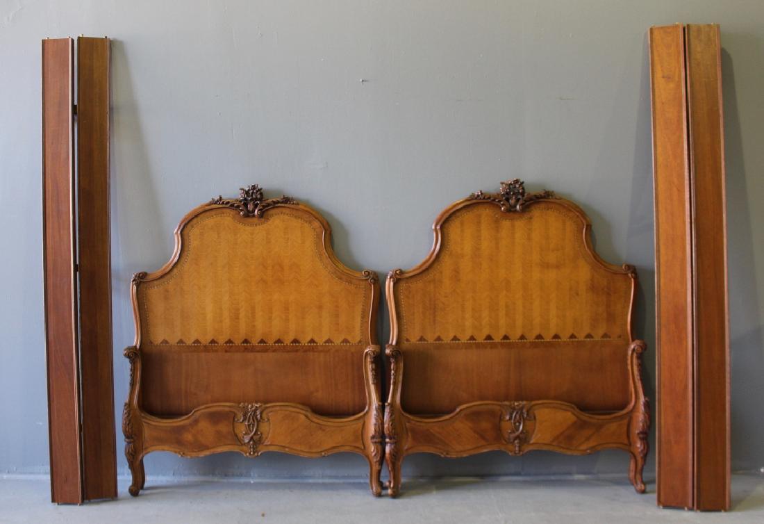 Pair of Ornate Twin Size Beds: Pair of ornate and inlay twin size beds: headboard 51.5"h, 42"w, 82"L, inside measurements 76" x 39". Carved pediment, cabriole legs, and relief carved footboard. Good condition with minor chip on one