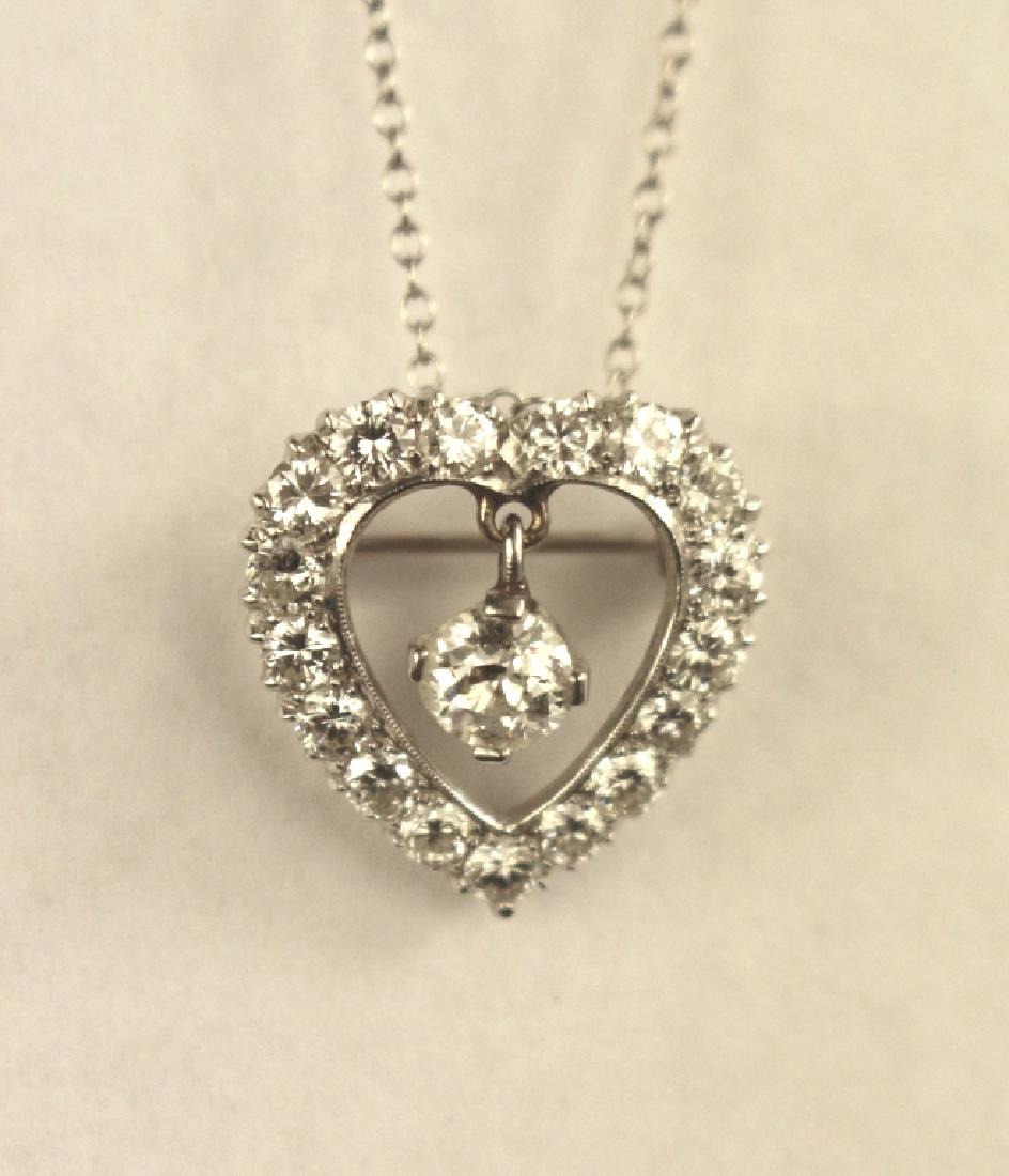 14K White Gold Diamond Heart Necklace: 14K white gold diamond heart pendant on chain, central stone .3 carats, diamond dangles in heart inset, surrounded by diamonds.