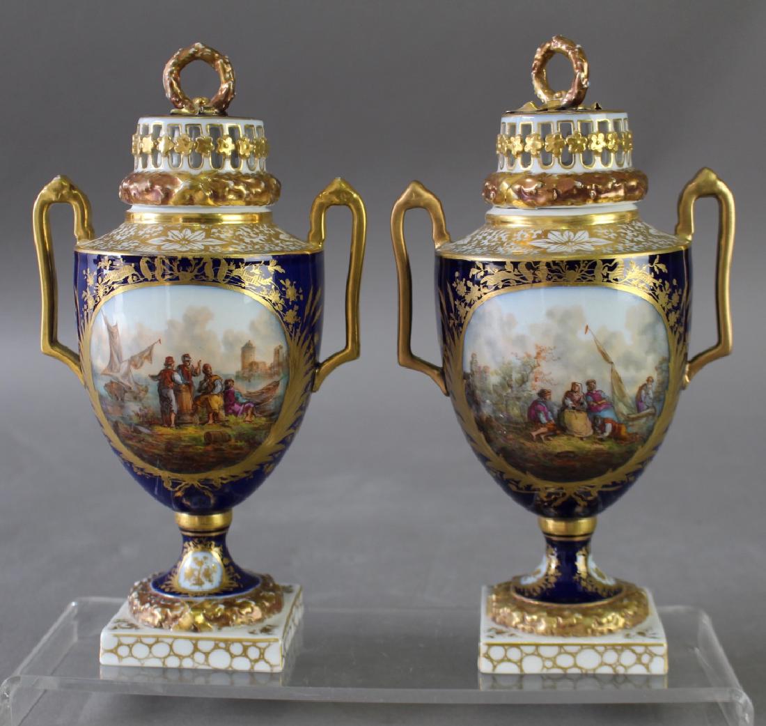 Pair Meissen Style Covered Urns: Pair of Meissen style covered urns, blue Augustus Rex or AR mark, hand painted scenes, 4 different, with reticulated covers, handle on one professionally restored, lots of gold still intact, 10.5".