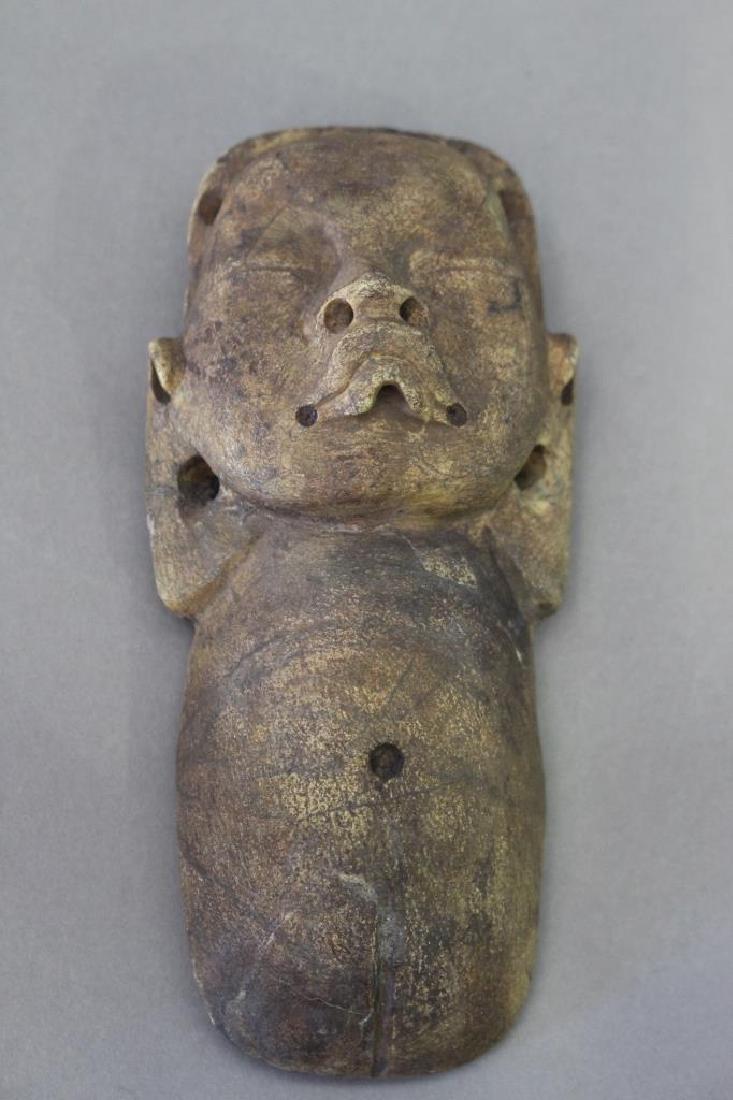 Pre-Columbian Mayan Stone Face: Pre-Columbian Mayan carved stone face, carved painted open lobed ears, pronounced frown on raised lips, closed eyes, predominant belly button, the object is drilled for neck hanging decoration and tap