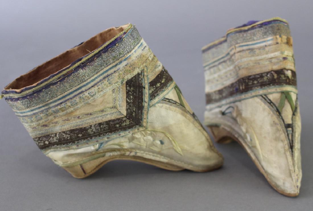 Chinese Lotus Bud Slippers: Chinese lotus bud slippers for bound feet, late 19th century, elaborate silk embroidery, arched leather sole and heel, 4" long x 1.5" at widest, some minor staining, but in remarkably good condition.